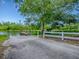 Concrete boat launch leads to a wooden dock on a serene lake, surrounded by green vegetation and a fence at 26608 E Cove Dr, Tavares, FL 32778