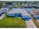 Waterfront single-story home with a metal roof, green lawn and a boat dock and lift on a canal at 26608 E Cove Dr, Tavares, FL 32778