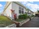 Charming home exterior featuring a lush garden bed and wooden walkway at 26608 E Cove Dr, Tavares, FL 32778