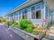 Exterior side view of home with flower beds, wood deck, stone accents, and many windows at 26608 E Cove Dr, Tavares, FL 32778