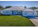 Charming one-story home with a well-maintained lawn, metal roof, and cozy front porch seating at 26608 E Cove Dr, Tavares, FL 32778