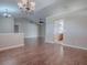 Open living room with wood flooring, view to the entryway and kitchen at 26608 E Cove Dr, Tavares, FL 32778