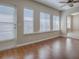Light-filled living room with wood floors, ceiling fan, and exterior door at 26608 E Cove Dr, Tavares, FL 32778