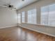 Bright living room featuring hardwood floors, ceiling fan, and natural light through windows and door at 26608 E Cove Dr, Tavares, FL 32778
