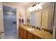 Bathroom featuring a granite countertop, vanity, framed mirror, and a walk-in shower at 2682 Edwards Ln, The Villages, FL 32162