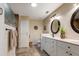 Well-lit bathroom featuring double sinks, tiled floors, and decorative oval mirrors at 27004 Nature View St, Leesburg, FL 34748