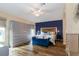 Bright bedroom boasts hardwood floors, stylish blue accent wall, and decorative furniture at 27004 Nature View St, Leesburg, FL 34748