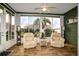 Bright sunroom featuring hardwood floors, large windows with views of the green backyard at 27004 Nature View St, Leesburg, FL 34748