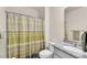 Bright bathroom featuring granite countertops, a toilet, and a shower with a colorful curtain at 28026 Cypress Springs Loop, Okahumpka, FL 34762