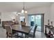 Elegant dining area with a wooden table, modern light fixture, and sliding glass doors at 28026 Cypress Springs Loop, Okahumpka, FL 34762