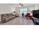 Spacious living room featuring tile flooring, a ceiling fan, and large window at 28026 Cypress Springs Loop, Okahumpka, FL 34762