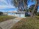 Side view of a single-story house featuring a driveway and a spacious lawn at 301 Clark St, Maitland, FL 32751