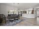 Open-concept dining area with elegant chandelier flows into modern kitchen with stainless appliances at 3261 Wise Way, The Villages, FL 32163