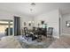 Elegant dining room features dark wood table, blue rug, and sliding door access to outdoor patio at 3261 Wise Way, The Villages, FL 32163