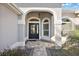 Inviting front entrance with glass door, arched entryway, and well-maintained landscaping at 3261 Wise Way, The Villages, FL 32163