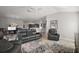 Comfortable living room with gray couches, stylish rug, and open to kitchen and dining area at 3261 Wise Way, The Villages, FL 32163