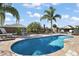 Beautifully landscaped pool area featuring a sparkling pool, mature palm trees, and comfortable outdoor seating at 3261 Wise Way, The Villages, FL 32163