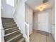 Foyer area featuring tiled floors, staircase with wood trim, and access to entry doors at 339 Winter Nellis Cir, Winter Garden, FL 34787