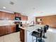 Open kitchen featuring a center island with seating, granite countertops, and wood cabinets at 339 Winter Nellis Cir, Winter Garden, FL 34787