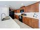 Kitchen with granite countertops, wood cabinets, modern black appliances, and tile floors at 339 Winter Nellis Cir, Winter Garden, FL 34787