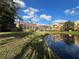 Exterior view of the building shows manicured lawn and reflection of the building in the pond at 3605 Conroy Rd # 535, Orlando, FL 32839