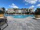 View of the community pool's clear, refreshing water framed by lush landscaping and condos at 3605 Conroy Rd # 535, Orlando, FL 32839