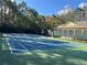 Well-maintained tennis court with new surface and net surrounded by lush trees at 3605 Conroy Rd # 535, Orlando, FL 32839