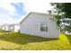 Exterior side view of house showing vinyl siding, window and adjacent yard at 3780 Viscaya Ct, The Villages, FL 32163