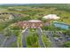 Stunning aerial shot of the community clubhouse, pool, tennis courts, and surrounding green landscape at 3808 Serena Ln, Clermont, FL 34711