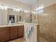 Modern bathroom featuring double sinks, tiled shower, and frameless glass at 3808 Serena Ln, Clermont, FL 34711