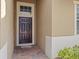 Close-up view of the front door framed by sidelights with brick-paver floor, and neutral-colored siding at 3808 Serena Ln, Clermont, FL 34711