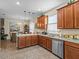 Well-lit kitchen with stainless steel dishwasher, wooden cabinets, and tiled floors at 3808 Serena Ln, Clermont, FL 34711