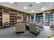 Community library featuring a large bookcase, comfortable seating, and ample natural light at 3808 Serena Ln, Clermont, FL 34711