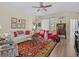 Bright living room with a white sofa, red armchairs, a glass coffee table, and a decorative rug on hardwood floors at 3808 Serena Ln, Clermont, FL 34711