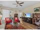 Cozy living room with hardwood floors, ceiling fan, white curtains, and comfortable seating arrangement at 3808 Serena Ln, Clermont, FL 34711