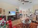 Open-concept living room with hardwood floors, TV, ceiling fan, and view into the adjacent kitchen at 3808 Serena Ln, Clermont, FL 34711