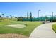 Community putting green with sand trap and sidewalk at 3808 Serena Ln, Clermont, FL 34711