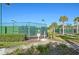 Community tennis courts surrounded by lush landscaping and secure fencing at 3808 Serena Ln, Clermont, FL 34711