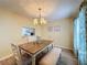 Dining room with a wooden table, bench, and a view into the kitchen at 3847 Eversholt St, Clermont, FL 34711