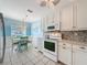 Bright kitchen with white cabinets, tile backsplash, stainless appliances, and breakfast nook with a view at 3847 Eversholt St, Clermont, FL 34711