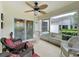 Enclosed porch featuring ceiling fan and comfortable wicker furniture, perfect for enjoying the outdoors at 3847 Eversholt St, Clermont, FL 34711