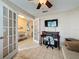 Bright home office featuring french doors, desk, large window and ceiling fan at 3847 Eversholt St, Clermont, FL 34711