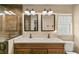 Bathroom with double vanity, decorative mirrors and wood-look tile in the walk-in shower at 40707 E Ninth Ave, Umatilla, FL 32784