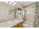 Traditional bathroom featuring a shower-tub combo with floral curtains and tiled walls at 40707 E Ninth Ave, Umatilla, FL 32784