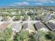 Aerial view of a residential neighborhood with tree-lined streets and well-kept lawns on a sunny day at 4078 Waltham Forest Dr, Tavares, FL 32778