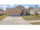 Inviting home exterior featuring a well-maintained lawn, and a neutral color palette at 4078 Waltham Forest Dr, Tavares, FL 32778