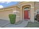 Close-up of the front door, with a landscaped walkway and a view of the attached garage at 4078 Waltham Forest Dr, Tavares, FL 32778