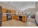 Modern kitchen with wood cabinetry, black appliances, and an open view into the living area at 4078 Waltham Forest Dr, Tavares, FL 32778