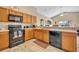 A modern kitchen area with stainless steel appliances and wood cabinets at 4078 Waltham Forest Dr, Tavares, FL 32778