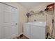 A clean laundry room featuring a washer, dryer, and shelving for storage at 4078 Waltham Forest Dr, Tavares, FL 32778